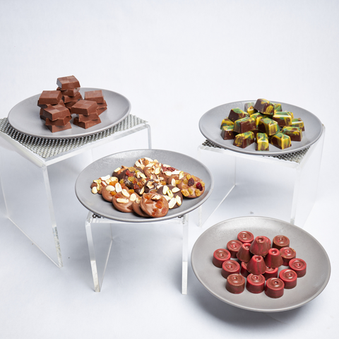 Four plates with various types of confectionery on a white background