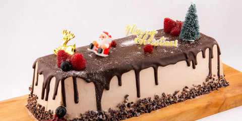 Christmas Yule Log cake with chocolate glaze and festive decorations by Bake N More Dubai
